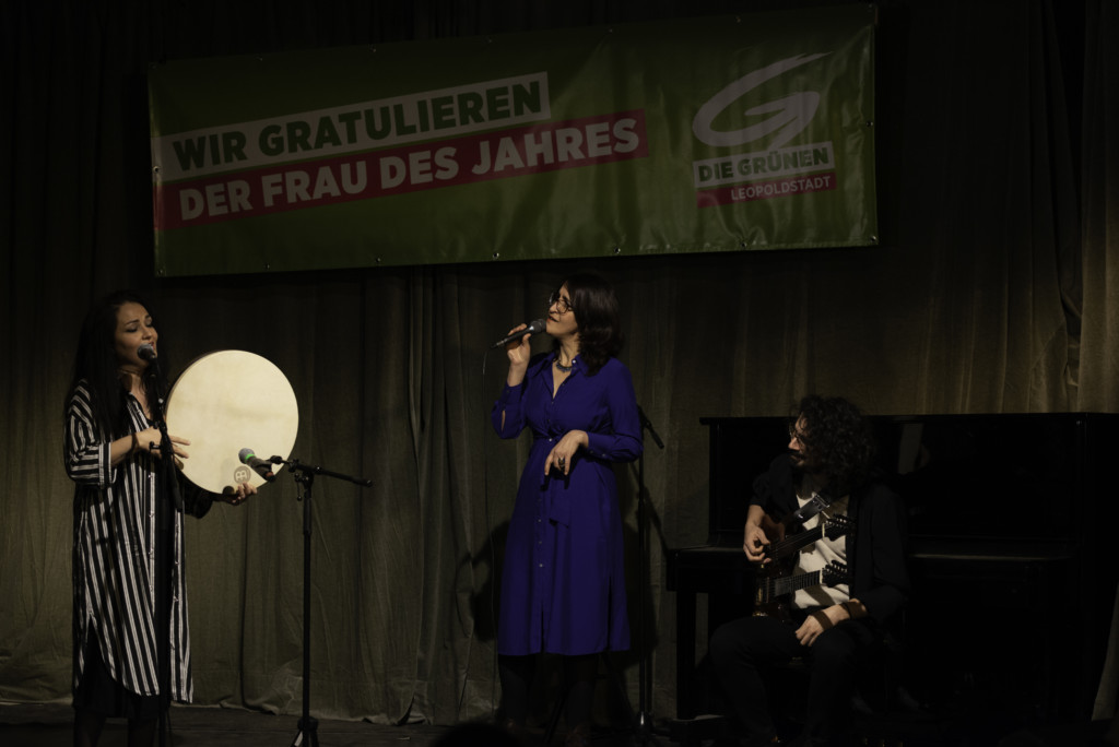 Die drei Musiker:innen Sakîna Têyna (singt), Basma Jabr (mit Handtrommel) und Mahan Mirarab (Gitarre) in Aktion
