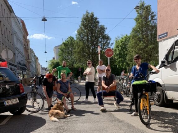 Supergrätzl Volkertviertel: Bezirksräti:innen vorm Volkertmarkt, mit Hund und Fahrrädern, fröhlich